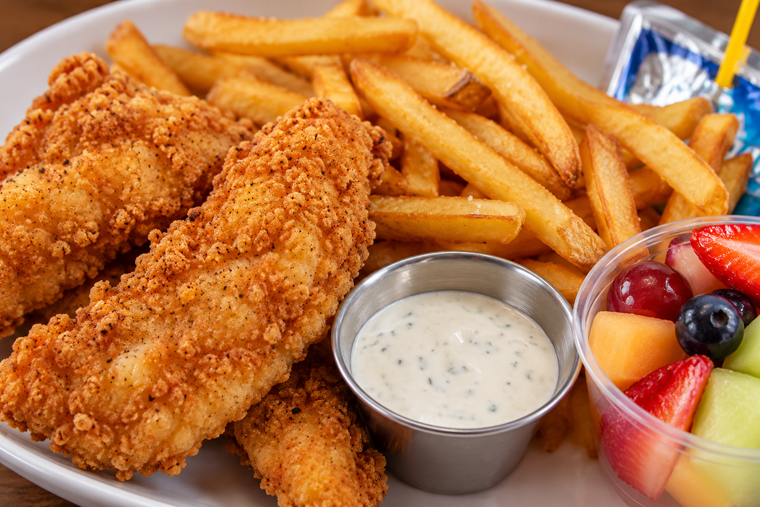 Kids, chicken strips and french fries. Welches fruit snack and a drink pouch